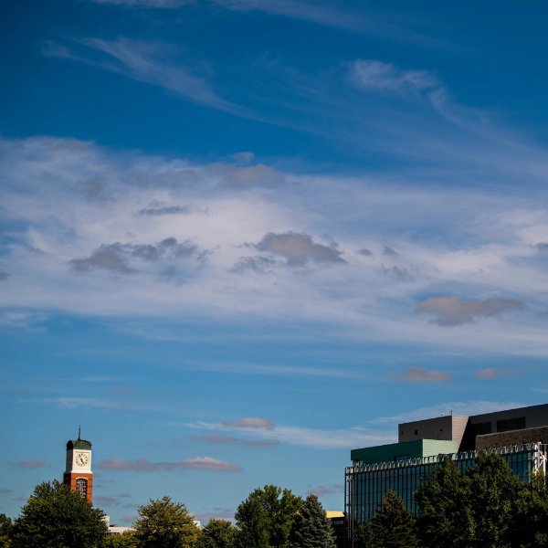 The carillon on the Allendale campus and the library building are set against a blue sky with wispy clouds.