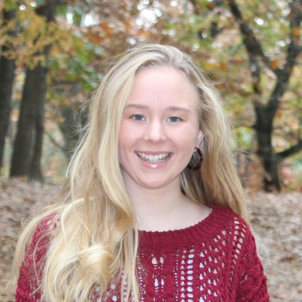 headshot of Christina Vann, outdoors near wooded area
