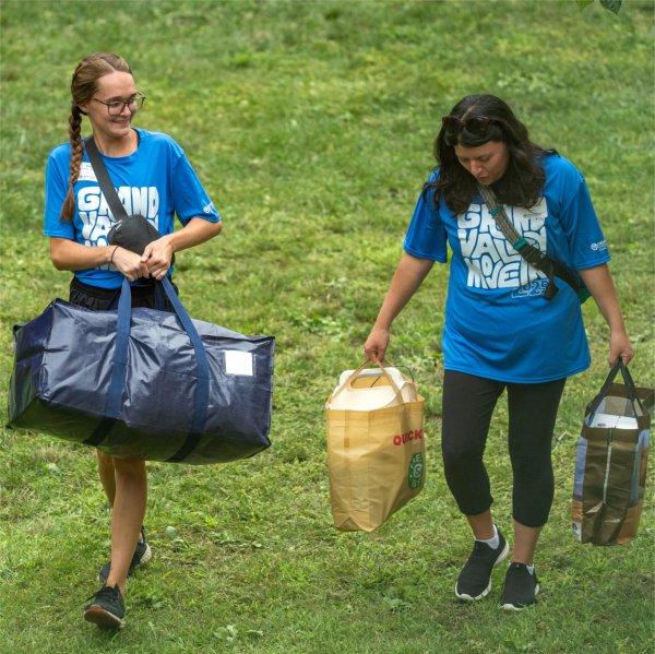 Volunteers help a student with their belongings during Valley Campus move-in.