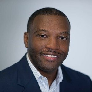 headshot of Ray Bennett, in shirt with open collar and blue suit coat