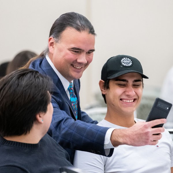 Bryan Newland takes a selfie with a student who is smiling.