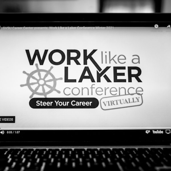 A black and white photo of a computer screen that shows text that reads work like a laker conference, steer your career virtually