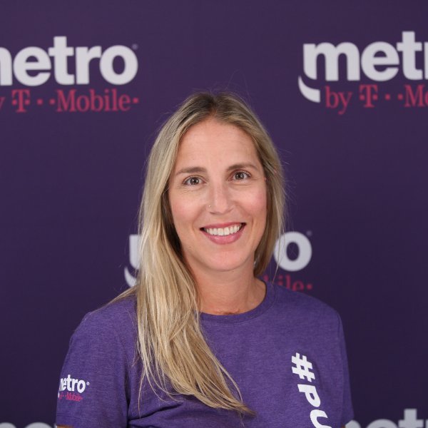 portrait of Tara Daggett in a purple shirt in front of a background for Metro by TMobile