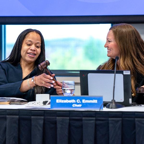 Mikyia Aaron takes the chair's gavel from Elizabeth Emmitt during a GVSU Board of Trustees meeting during which Aaron was elected chair