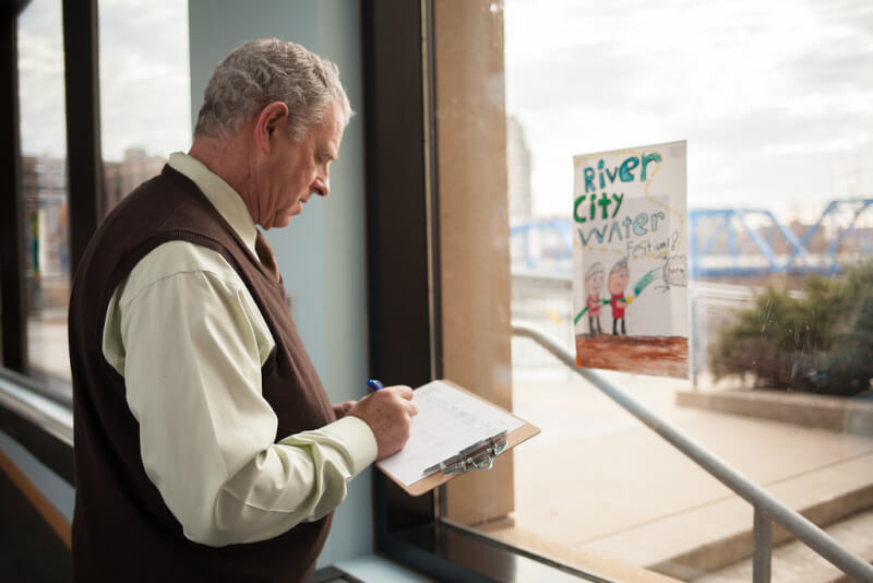 Barry Kanpol, dean of the College of Education, judges a poster contest for the River City Water Festival.