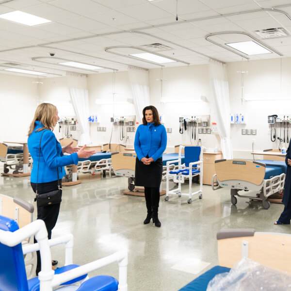 three women standing in a lab; including governor, President Mantella and Spectrum Health CEO