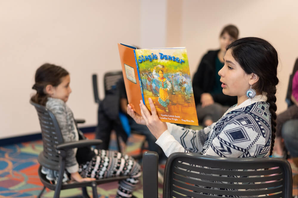Jade Green, 12, reads "Jingle Dancer" to a group of children at a book club called, Social Justice Begins With Me, created by Paola Leon, associate professor of social work.
