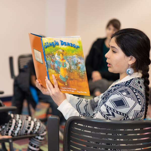 Jade Green, 12, reads "Jingle Dancer" to a group of children at a book club called, Social Justice Begins With Me, created by Paola Leon, associate professor of social work.
