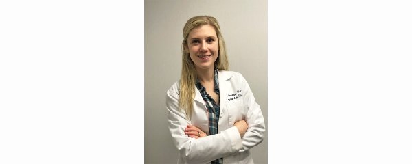 Lara Gavaldon is standing in a white lab coat with a stethoscope in this photo