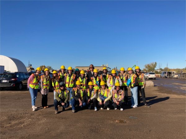 students and group in hardhats outside recycling center