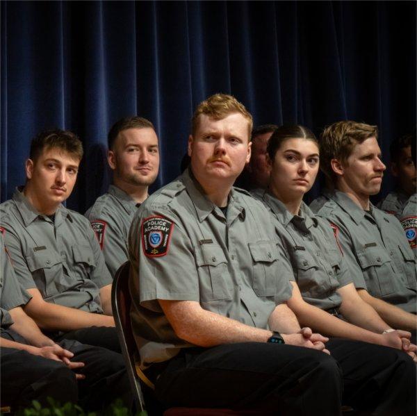Grand Valley Police Academy Recruits sit on stage at their graduation ceremony.