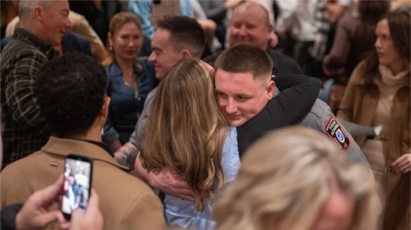 A police academy graduate greets someone with a hug after the commencement ceremony on December 18th.