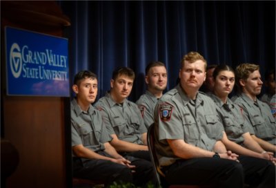 Grand Valley Police Academy Recruits sit on stage at their graduation ceremony.