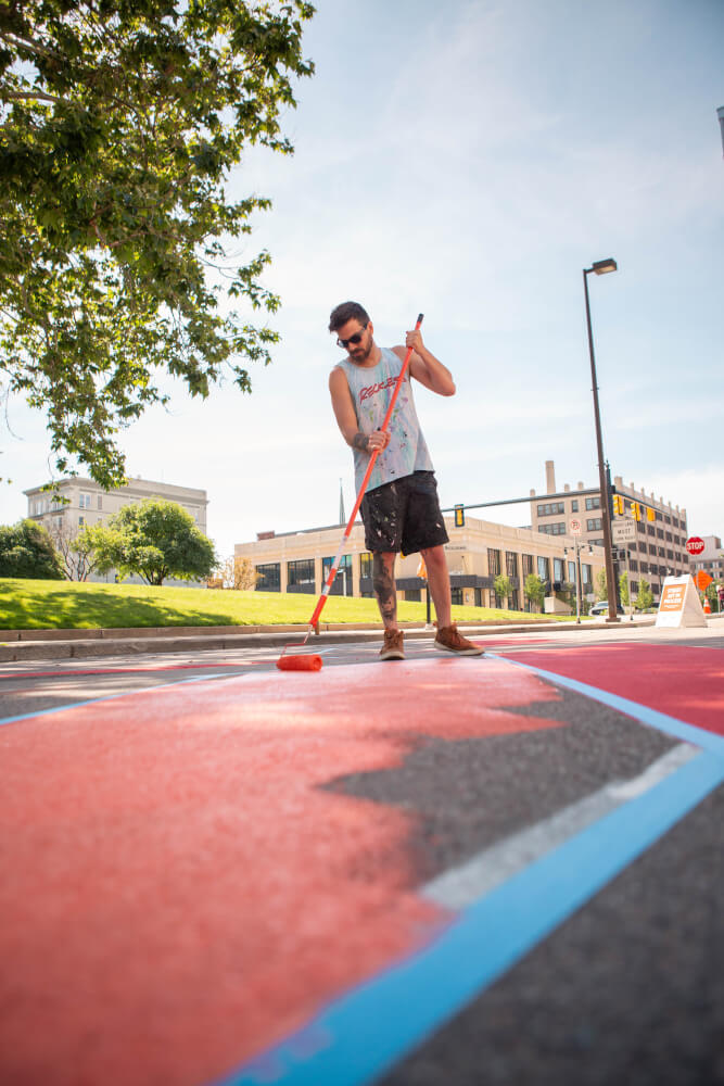 Joey Salamon paints a street mural.