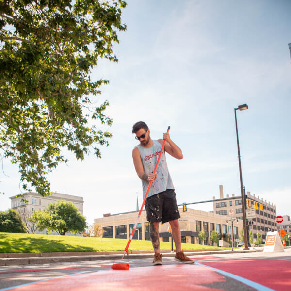 Joey Salamon paints a street mural.