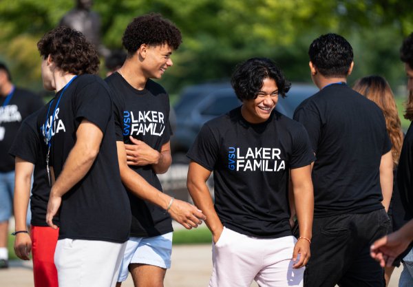  Laker Familia college students laugh together.