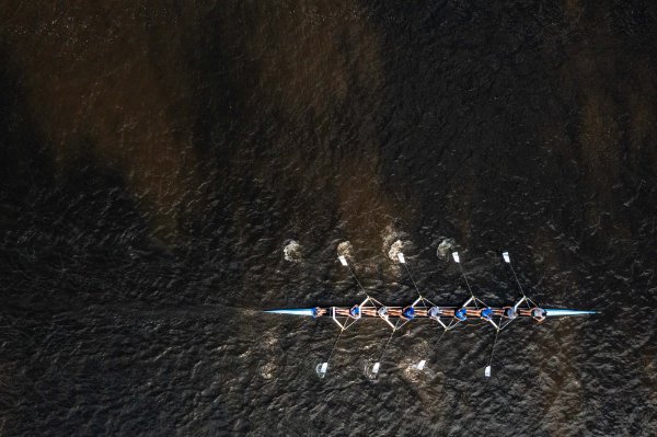  A drone photo of a row crew rowing on a river. 