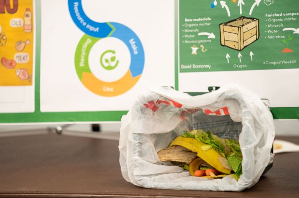A display on composting shows a plastic bag with bananas, greens, carrots and other items that could be composted.