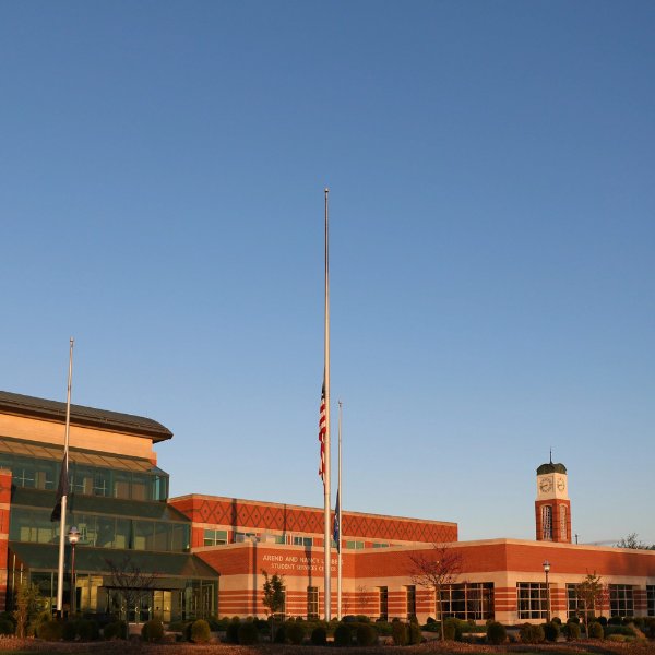 Student Services Building with flag at center, carillon tower in background