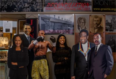Jada Dobbins stands in the middle of posters of prominent Black figures
