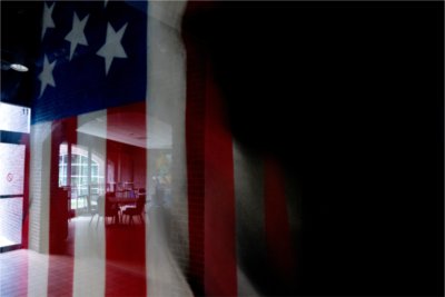 An American Flag with a shadow in front of it.