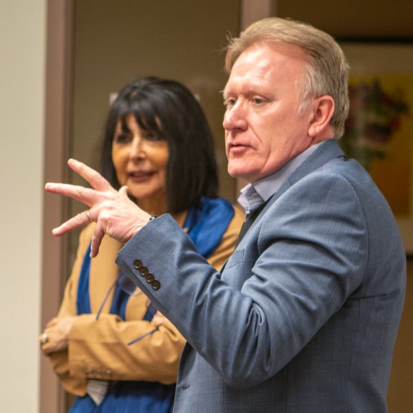 Paul Stansbie, associate dean with the College of Education and Community Innovation, speaks with the Leadership Program cohort as President Philomena V. Mantella looks on.