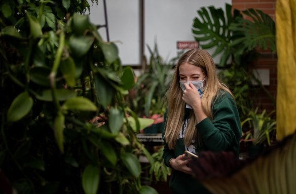 Madison Henson holds her nose after smelling the corpse flower April 19 at the Barbara Kindschi Greenhouse.