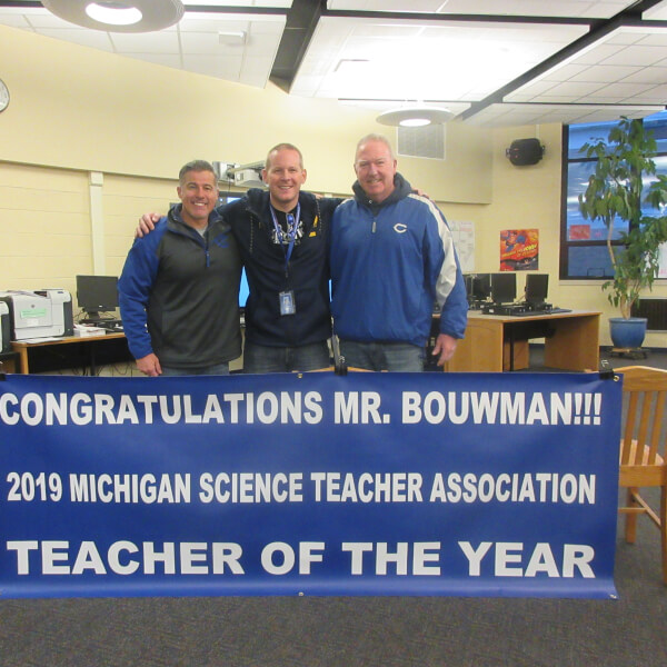Jeff Bouwman, '03, (center) has been named the 2019 Middle School Science Teacher of the Year by the Michigan Science Teachers Association.
