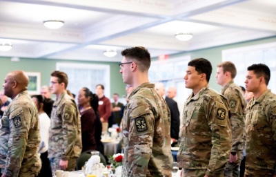 Students in uniform stand for the National Anthem during a Veterans Day breakfast