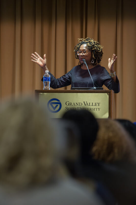 Woman stands behind podium