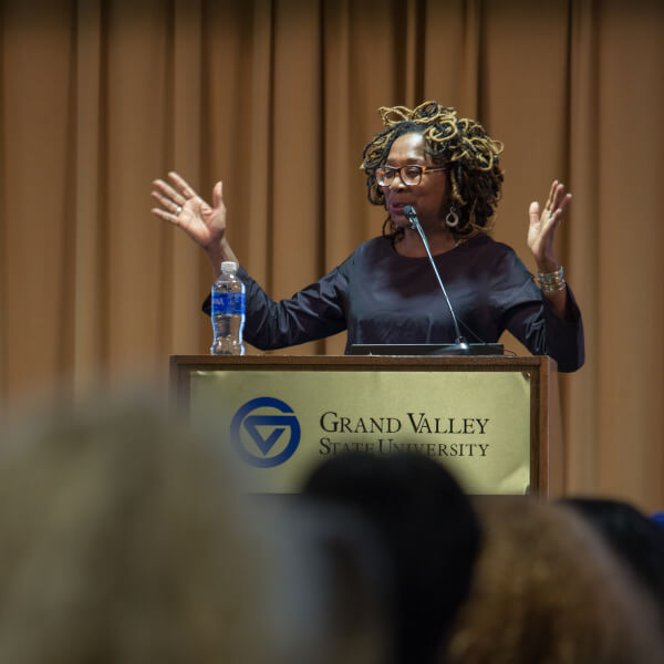 Woman stands behind podium