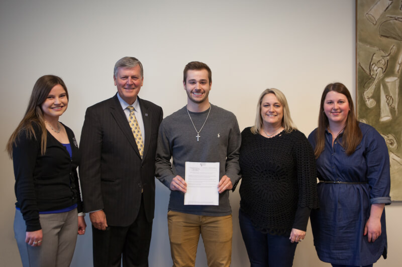 Trevor Fairfield, center, with President Haas and family. 