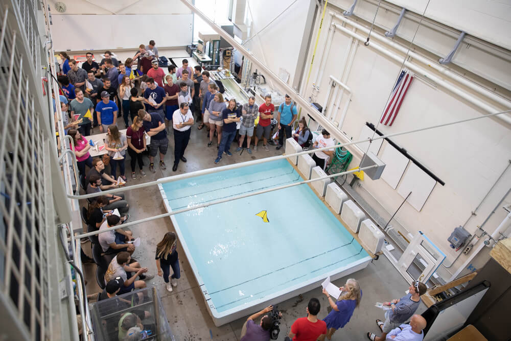 Students watch a boat cross the test tank.