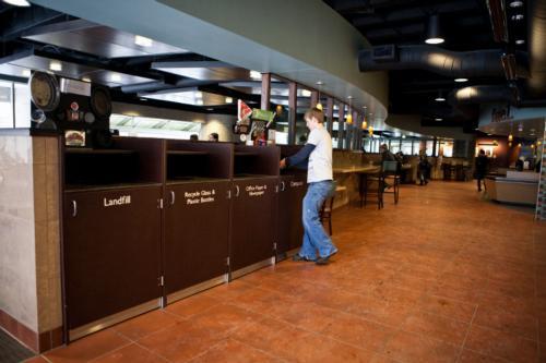 A student places items in a compost bin at the Commons.