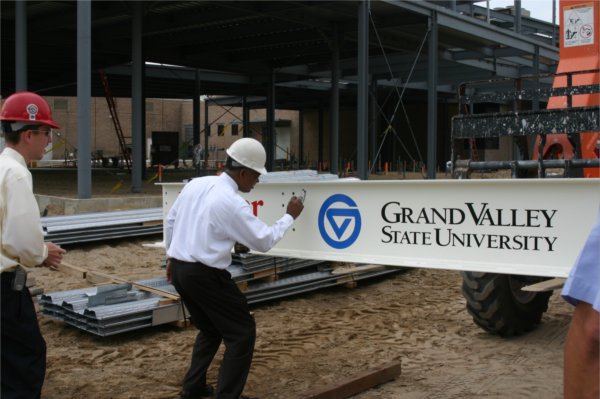 Moyer signs a banner at a building site