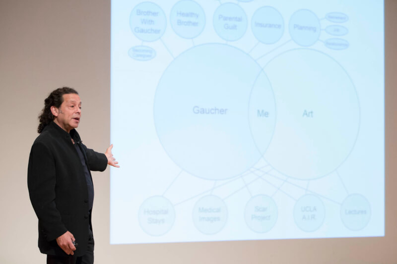 man on stage in front of screen