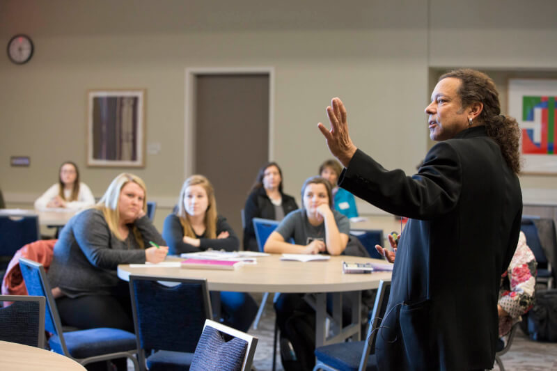 man in front of room speaking to audience