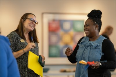 Diane Fleser, grant program manager for the Muskegon Innovation Hub, laughs with one of the Hub Direct Grant recipients. 