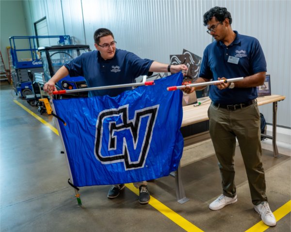student and professor with GV flag on flag pole