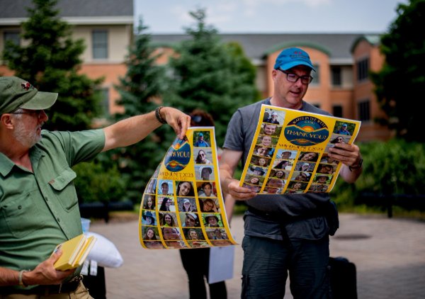Professors Peter Wampler and Peter Riemersma unroll their thank you posters, a gift from students on the trip. 