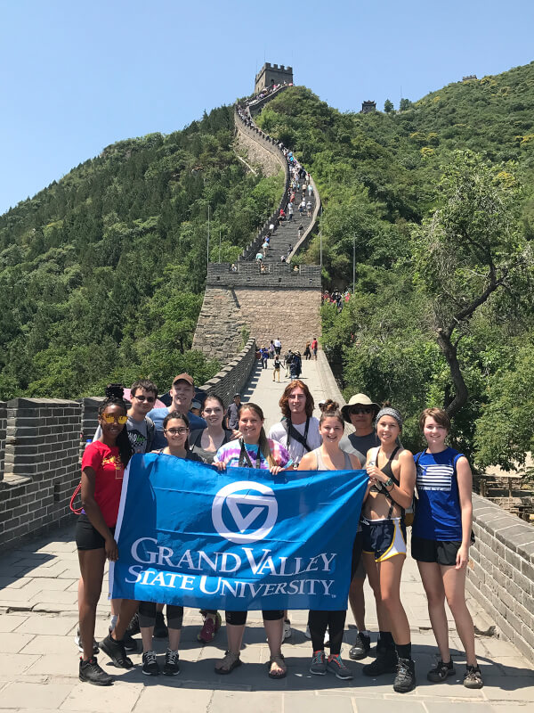 group of students on Great Wall of China holding Grand Valley flag