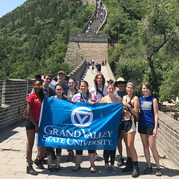 group of students on Great Wall of China holding Grand Valley flag