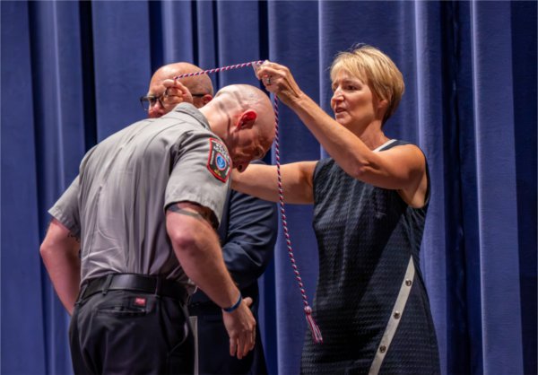 Retired Kalamazoo Department of Public Safety Chief Karianne Thomas honors graduate David Woike during the Police Academy Graduation Ceremony at the Louis Armstrong Theatre on August 21.