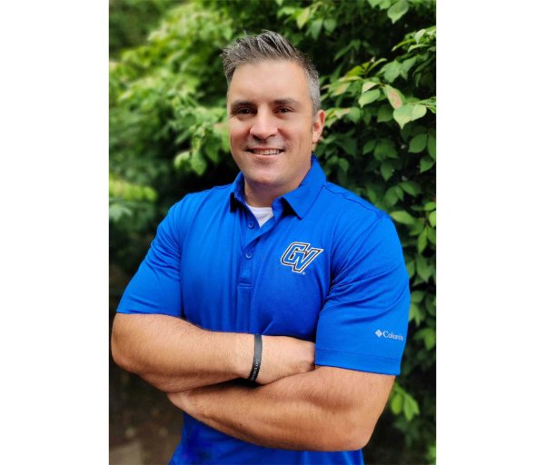 Shane Scherer standing outside in a blue GV golf shirt