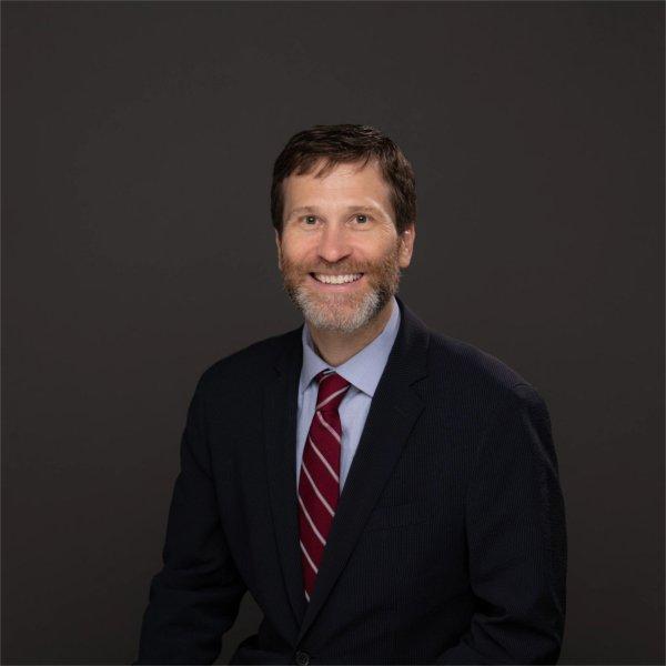 Sean Lancaster in dark suit, light blue shirt