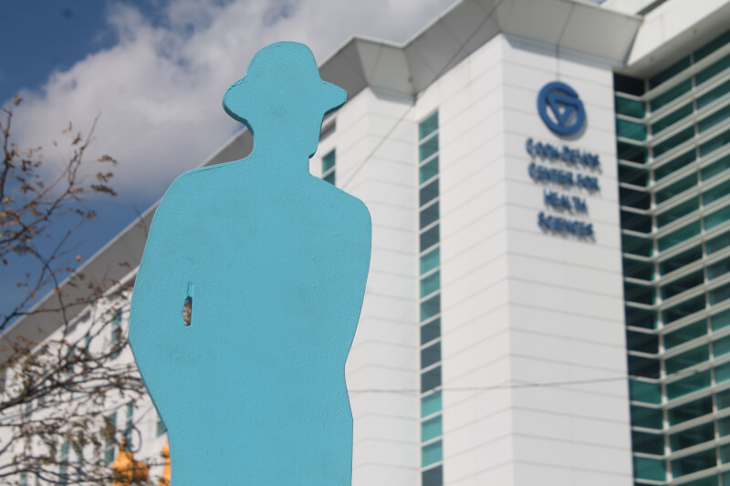 A blue man sculpture, part of the entry "The Man in the City: A conversation of numbers" can be seen on the roof of the Cook-DeVos Center for Health Sciences during ArtPrize.