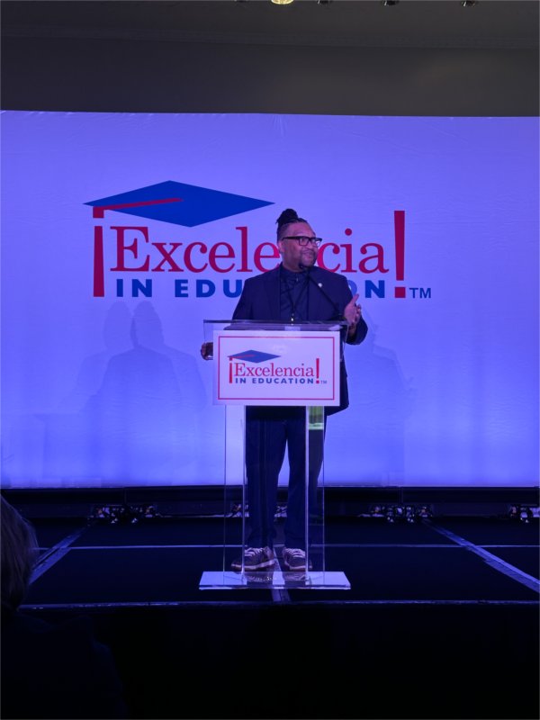 VP Robert Shorty at podium with Excelencia in Education on screen behind him