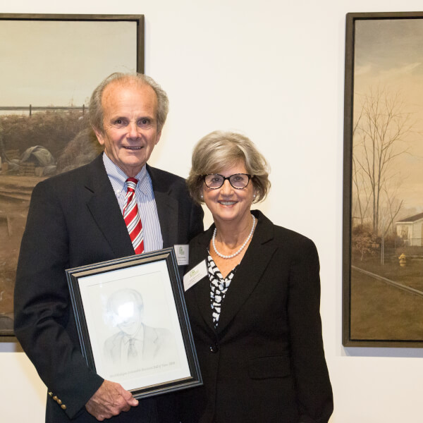 Norman Christopher and wife Anita Christopher with his West Michigan Hall of Fame portrait after the induction ceremony at UICA