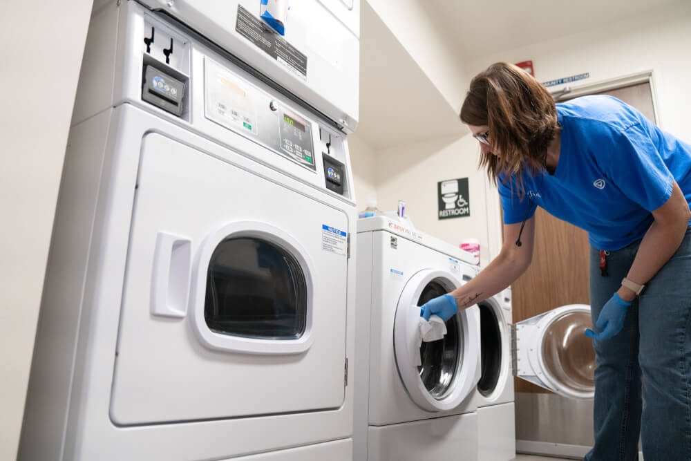 woman wiping down laundry machine