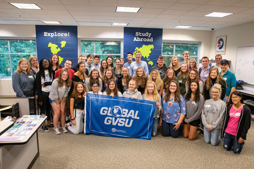 group of 40 students holding GVSU Global flag